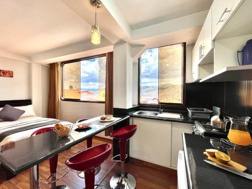 库斯科Allincay Cusco Apart Hotel的柜台前带红色凳子的厨房