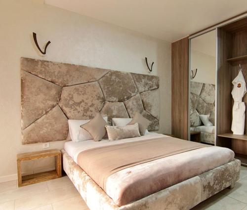 米戈韦Four Seasons In Carpathians的一间卧室配有一张大床和石制床头板