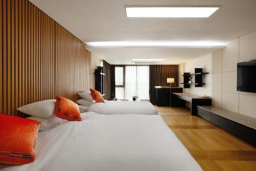 西归浦市Shin Shin Hotel Jeju Ocean的酒店客房设有两张床和电视。