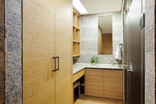 西归浦市Shin Shin Hotel Jeju Ocean的一间带木制橱柜和水槽的浴室