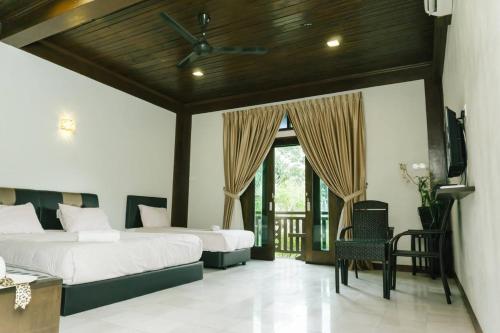 瓜埠Singgahsana Villa的一间卧室配有两张床和电视。