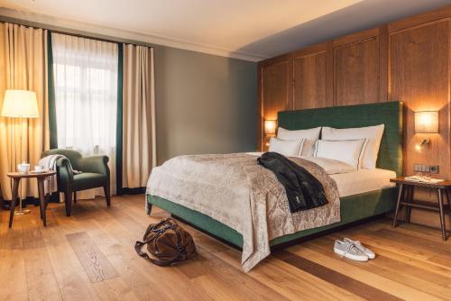 施伦斯Posthotel Taube的一间卧室配有一张大床和绿色床头板
