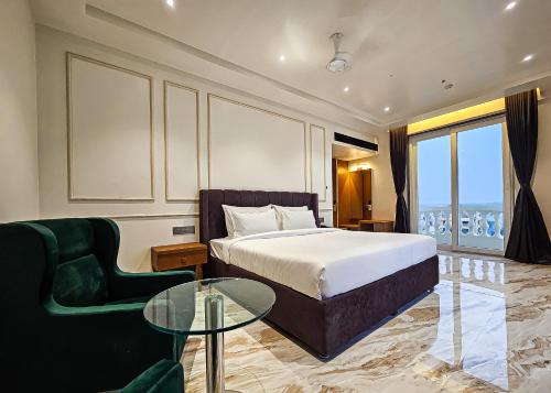索姆纳特The S Crown Somnath的酒店客房设有一张床铺和一张玻璃桌