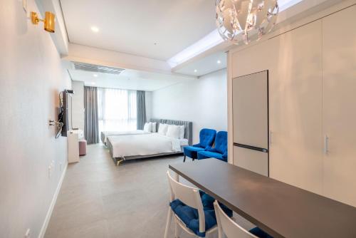 釜山Centum Convention Hotel In Centum的配有一张床和一张桌子及椅子的房间