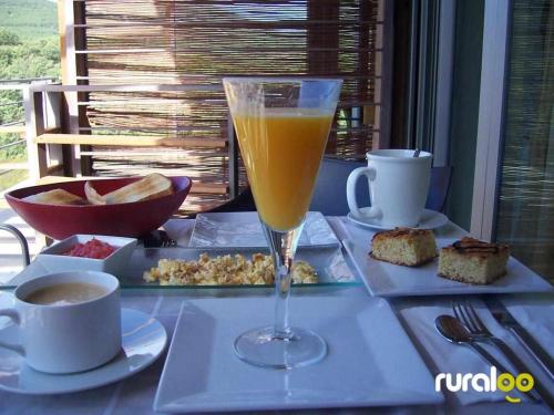 Hontanar瑞法吉欧克里斯托尔酒店的桌上放着一杯橙汁,放着食物