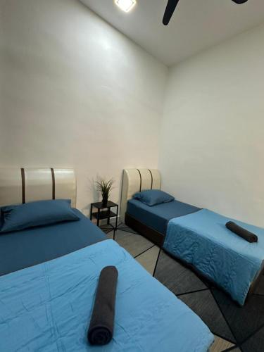 亚娄MK Homestay Perlis的一间设有两张蓝色床单的床的房间