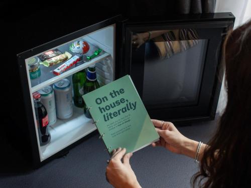 米兰21 House of Stories Navigli的坐在冰箱前拿着书的妇女