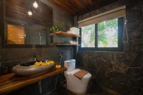 和平Vayang Retreat and Camping的一间带水槽和卫生间的浴室以及窗户。