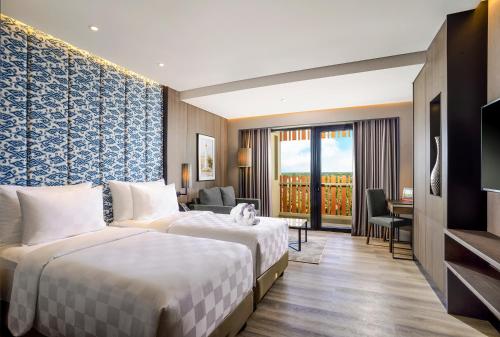TemonSwiss-Belhotel Airport Yogyakarta的酒店客房配有两张床和一张书桌