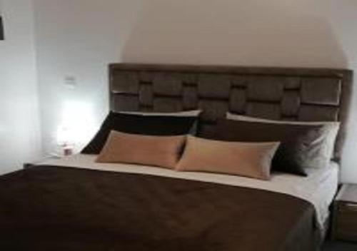 丹吉尔Appart Hôtel Tanger Paname的一间卧室配有一张大床和软垫床头板