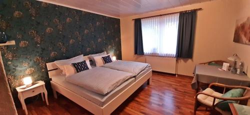 HambergenMotel Hamberger Krug的一间卧室配有一张床、一张桌子和一个窗户。