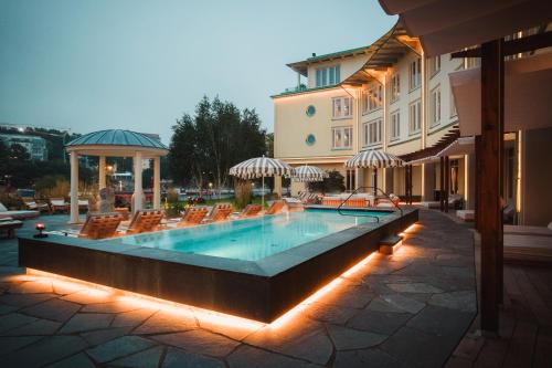 南泰利耶Ad Astra by Elite - Hotel, Spa & Resort的一座带椅子的游泳池以及一座建筑