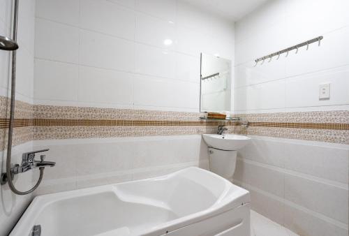 胡志明市King Hotel Saigon Airport的白色的浴室设有水槽和卫生间。