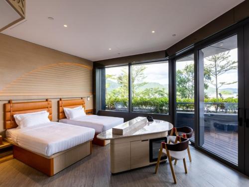 香港WM Hotel Hong Kong, Vignette Collection的一间卧室设有两张床、一张桌子和窗户。
