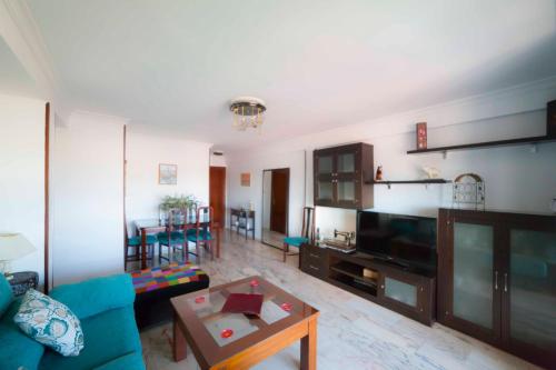 塞维利亚SJE - Shiny apartment close to the river的客厅配有蓝色的沙发和桌子