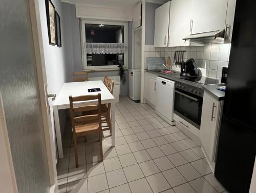 诺伊斯Monteurwohnung Neuss的厨房配有白色橱柜和桌椅