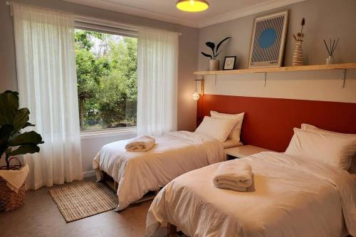 美德罗巴斯The Yellow Koala - Vibrant Home in Medlow Bath的带窗户的客房内的两张床