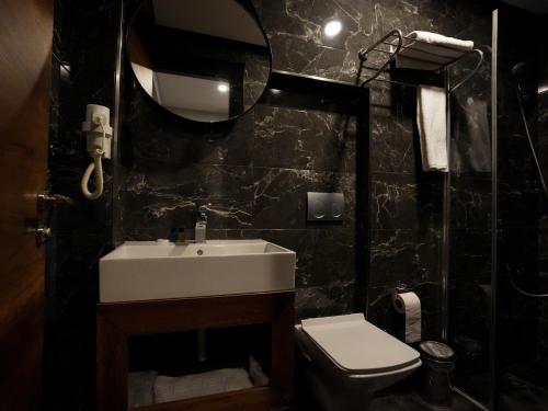 伊斯坦布尔Zalel Hotels Laleli的一间带水槽、卫生间和镜子的浴室