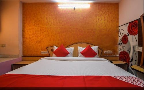 乌代浦Pax in hotel的一间卧室配有一张带红色枕头的大床