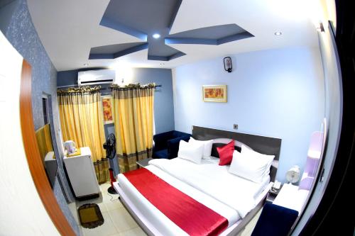 AroRemzy Hotel & Suites, Olomore的一间卧室配有一张大床和吊扇