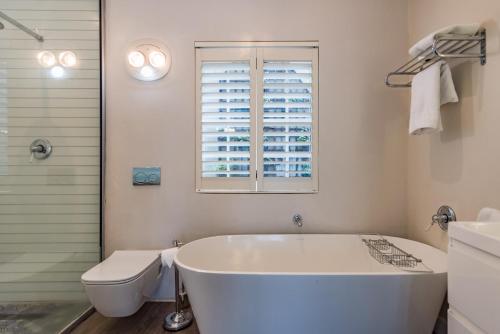 约翰内斯堡科里柯精品酒店的带浴缸、卫生间和窗户的浴室