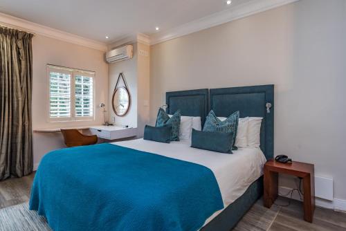 约翰内斯堡科里柯精品酒店的一间卧室配有一张带蓝色毯子的大床