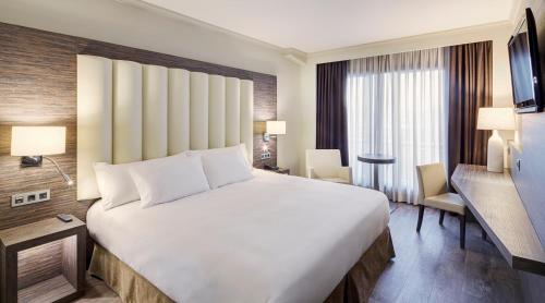 格拉纳达Gran Hotel Luna de Granada的一张大白色的床,位于酒店客房内