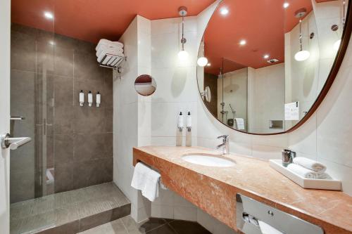 皮托Nest Paris La Défense - MGallery的一间带水槽、镜子和淋浴的浴室