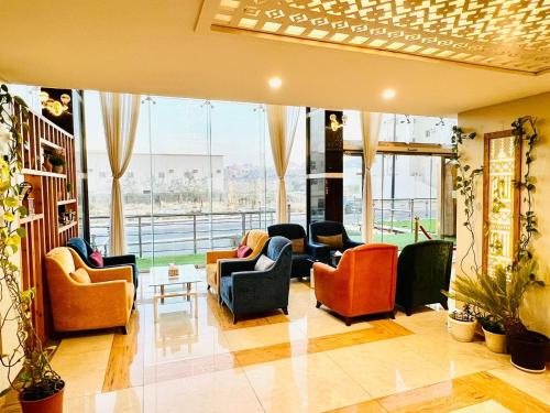 艾卜哈Shatha Abha Furnished Units的带沙发和椅子的客厅以及窗户。