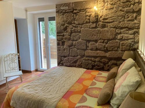 勒米伊巴斯蒂德·奥利维尔酒店的卧室内的一张床位,卧室设有石墙