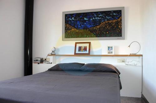 厄尔·波普瑙·德尔·戴尔Llevantada - Casa en Poblenou del Delta con piscina privada y barbacoa的卧室配有一张床,墙上挂有绘画作品