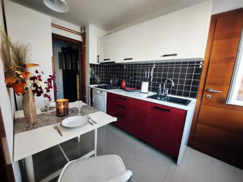 锡萨克B&B Onyx的一个带红色橱柜和水槽的小厨房