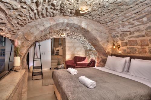 萨法德סוויטת גן עדן - Gan Eden Suite的卧室配有一张石墙内的大床