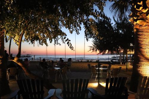 库萨达斯Aqua Fantasy Aquapark Hotel & Spa - Ultra All Inclusive的海滩上的日落,人们坐在桌子上