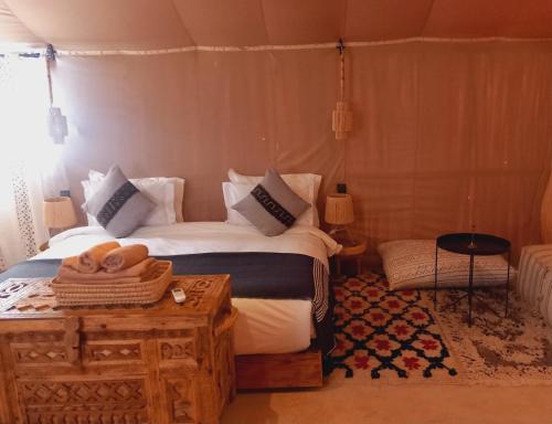 AdrouineNight sky luxury camp的一间卧室配有一张床和一张桌子,上面配有毛巾