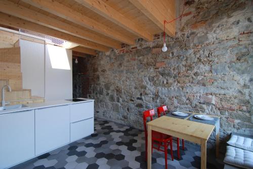 萨尼科拉卡萨德拉齐亚酒店的厨房配有桌椅和砖墙
