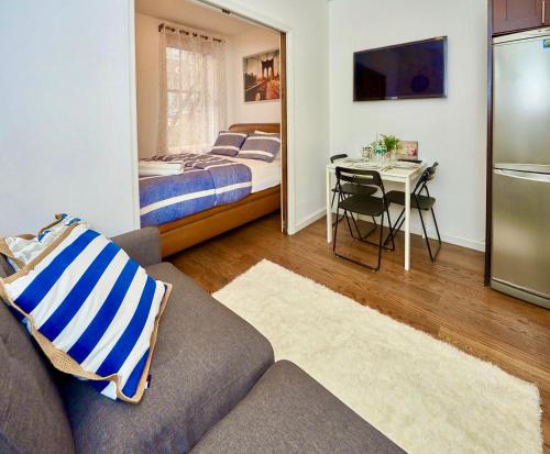 纽约Cozy FamilyFriendly Apartment with 2 Bedrooms的带沙发、床和桌子的客厅