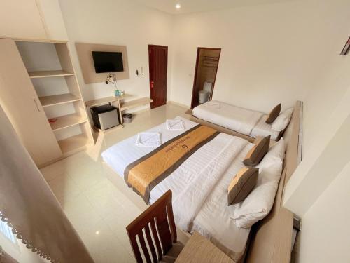 万荣Galaxy VangVieng Hotel的一间卧室配有两张床和电视。