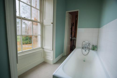 兰彼得Gelly Dylan Thomas Paradise的一间带白色浴缸和窗户的浴室