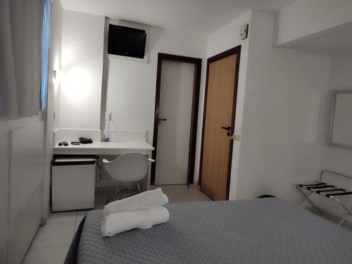 贝洛奥里藏特Hotel Oscar Gold Savassi的一间卧室配有一张床、一张桌子和一个水槽