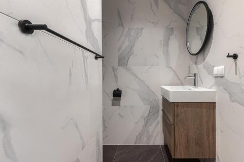 格但斯克Scala Apartamenty by Moderna Profit- Łąkowa 60K的白色的浴室设有水槽和镜子