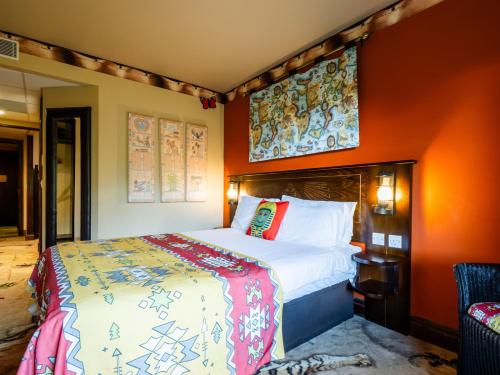 温莎LEGOLAND(R) Windsor Resort的一间卧室配有一张带橙色墙壁的大床