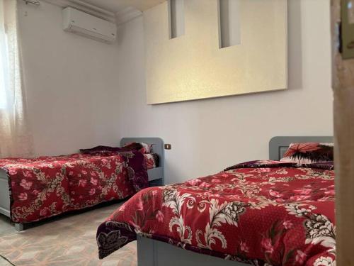 米多恩Villa luxe calme djerba的一间卧室配有红色的床和镜子