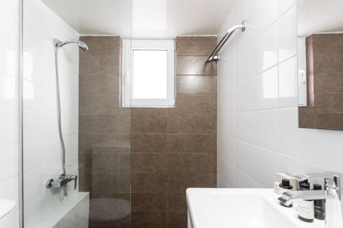 雅典Comfy 1BR Apartment in Ampelokipoi by UPSTREET的带淋浴和盥洗盆的白色浴室