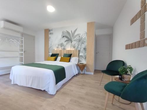 罗德里戈城Ciudad Rodrigo Centro的一间卧室配有一张大床和两把椅子