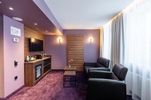 里加阿瓦隆会议酒店的客厅配有两张沙发和一台电视机