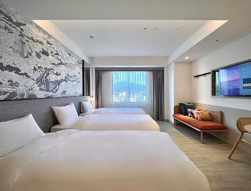 台北见潭璞旅的一间酒店客房,设有三张床和一台平面电视