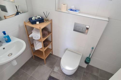 Bayit Weganוגאס的浴室配有白色卫生间和盥洗盆。