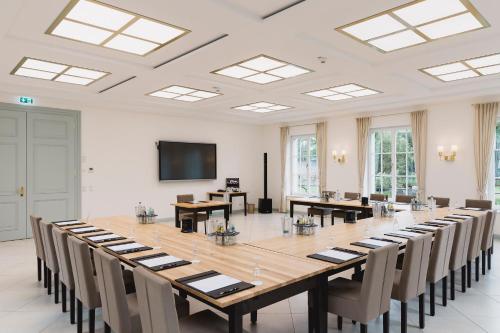 伊普霍芬泽赫特克勒浪漫酒店的大型会议室,配有大桌子和椅子