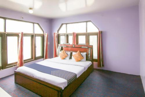 斯利那加SPOT ON Valley Meadow的一间卧室设有一张大床和两个窗户
